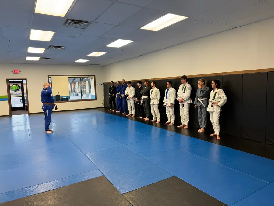 Roots Brazilian Jiu-Jitsu students lined up with their coach