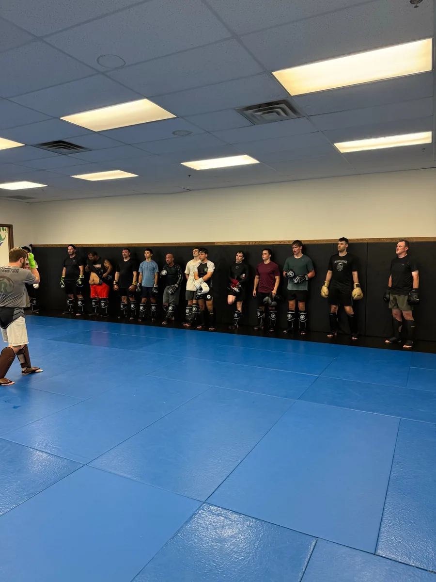 Roots students with gloves and shin guards attending striking class